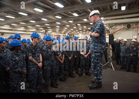 SASEBO, Japan (Sept. 26, 2017) Elektroniker 3. Klasse Josua Handegard, von Evansville, Ind., (Links, Mikrofon) an die amphibious Transport dock Schiff USS Green Bay (LPD 20) zugeordnet, spricht mit Vice Adm. Tom Rowden, Commander, Naval Surface Kräfte, während ein Frage- und Antwortspiel der Hände. Rowden besucht Flotte Aktivitäten Sasebo, der Heimat des 7. US-Flotte des Vorwärts - Bereitgestellt amphibische Schiffe, nach vorn, um besser zu verstehen, - Bereitschaft, Herausforderungen und die Rolle der neuen Naval Surface Gruppe Western Pacific Organisation zu besprechen. Stockfoto