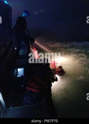 Coast Guard Station Castle Hill 45-Fuß-antwort Crew holt ein narragansett Feuerwehr Rettungsschwimmerin und die Frau, die von den Felsen aus der Nähe von CG-Haus in der Narragansett Bay, Rhode Island, Mittwoch, Sept. 27, 2017 fiel. Die Frau wurde wieder Station Castle Hill auf Warten auf Emergency Medical Services. Stockfoto