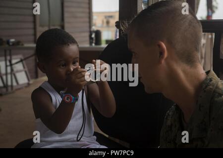 Us Marine Sgt. Austin Cody, mit Joint Task Force - Leeward Inseln, lässt Raeshawn Noel sein Foto bei Douglas-Charles Flughafen in Dominica, Sept. 26, 2017. Noel, 3, ist eine von der US-amerikanischen Bürger evakuiert, die von der Task Force und der Abteilung, in die Folgen des Hurrikans Maria. Us-Mitglieder mit Joint Task Force - Leeward Inseln, eine Evakuierung Control Center am Flughafen Douglas-Charles in der freiwilligen Evakuierung von US-Bürgern auf Dominica gestrandet nach Hurrikan Maria zur Verfügung gestellt haben. Auf Anfrage der Partnerländer und sowohl das State Department und den USA EIN Stockfoto