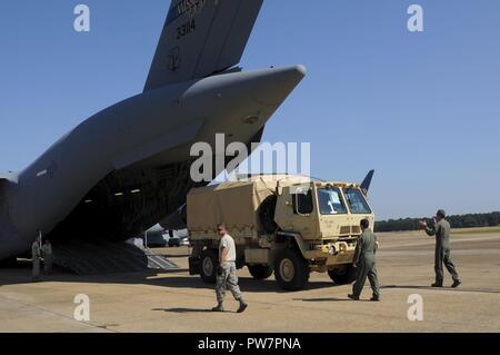 Flieger an die 183 d Airlift Squadron und Fliegern, die 172 d Logistik Bereitschaft Squadron Last eine Familie von Medium taktische Fahrzeuge an die 184 Sustainment Command in Laurel, Fräulein zugeordnet, auf eine C-17 Globemaster III bei Thompson Feld, Jackson, Miss., Sept. 28, 2017. Der Mississippi Army National Guard und Mississippi Air National Guard arbeiten zusammen, um die Versorgung der St. Thomas zu liefern in der Zeit nach dem Hurrikan Maria zu unterstützen. Stockfoto