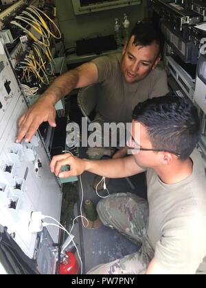 Wie tausende in Puerto Rico weiterhin für Hilfe nach dem Hurrikan Maria zu weinen, Soldaten eines Unternehmens, 63. Expeditionary Signal Battalion, 35th Theater taktische Signal Brigade verstärken die in ihrer dunkelsten Stunde zu erleichtern. Im Katastrophenfall erhalten Nahrung und medizinische Hilfe für die Opfer ist die Priorität Nummer eins aber Kommunikation spielt eine äußerst wichtige Rolle bei der Gewährleistung, dass die Beihilfen. Mehr als oft nicht die Elektrizität und Telefon- und Infrastrukturen sind schwer beschädigt und unbrauchbar gemacht, was die Kommunikation unmöglich. Wie wir sehen mit Lektionen von Hurri Stockfoto