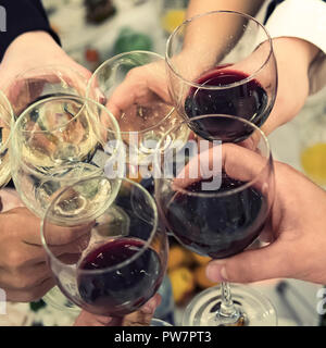 Die Menschen anstossen oben reataurant Tisch zu einem festlichen Anlass. Trinken Toast und klirren Trinkgläser bei einem Abendessen. Das Trinken von Wein Stockfoto