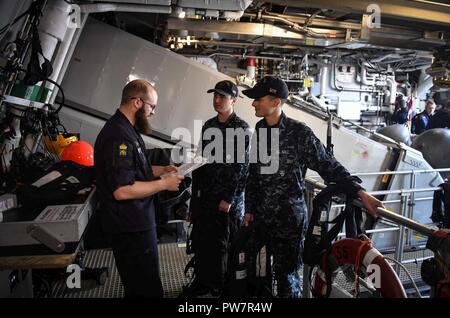 Ostsee (Sept. 26, 2017) Segler der Arleigh-Burke-Klasse geführte Anti-raketen-Zerstörer USS Oscar Austin (DDG79) eine Tour durch das Schwedische Visby erhalten-Klasse corvette HSwMS Karlsand (K35) Sept. 26, 2017. Oscar Austin auf einer routinemäßigen Bereitstellung unterstützen die nationale Sicherheit der USA Interessen in Europa und der zunehmenden Theater Sicherheit gute Zusammenarbeit und freuen uns naval Präsenz in den USA 6 Flotte Bereich der Operationen. Stockfoto