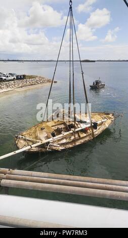 Ein Segelboot durch den Hurrikan Irma verdrängt wird, in der Nähe des Fleming Key Bridge in Key West, Florida, Sept. 28, 2017 gehisst. Mitglieder der Küstenwache und der Fisch- und Wildlife Conservation Kommission durchgeführten Bewertungen und einen Plan das Schiff ohne eine Gefährdung der Umwelt oder Ersthelfer auf Szene zu heben formuliert. Stockfoto