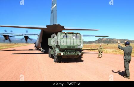 Soldaten aus der dritten Bataillon 157 Field Artillery und Fliegern aus dem 19 Airlift Wing, Little Rock Air Force Base, Arche, die Teilnahme an einem gemeinsamen Training in Fort Carson, Colo Sept. 20, 2017. Die Soldaten und Piloten praktiziert die Bekämpfung laden, simulierten feuern und Nachladen eines High Mobility Artillery Rocket System zwischen Colorado Springs, Colo., Flughafen und einer Kiesgrube Landeplatz im Camp Red-Devil auf Fort Carson. Stockfoto