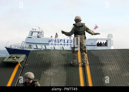 Die Soldaten an Bord eines 130 Fuß verbesserte Ribbon Bridge von der Michigan National Guard 1437th Multi-Role Brücke Unternehmen, und das Personal an Bord einer Fähre Shepler® Boot arbeiten zusammen, um während des Betriebs Shining Star, Sept. 23, 2017. OSS ist ein Emergency Management Übung in den Straßen von Mackinac, die zusammen bringt auf Bundes-, Landes- gemeinschaft und zivile Teilnehmer Soforthilfemaßnahmen zu proben. (Michigan National Guard Stockfoto