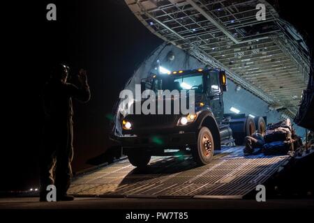 Ein Sattelschlepper Rücken auf eine C-5 Galaxy Flugzeug zu Travis Air Force Base, Calif. zugewiesen, um eine 47.000 Pfund Generator am Internationalen Flughafen San Juan, Puerto Rico, Sept. 29, 2017. Der Generator wird zu den San Juan Kombiklemme Radar Ansatz und en-route-Center, transportiert werden Backup Power für Radar- und Kommunikationssysteme in der Anlage zur Verfügung zu stellen. Die Einrichtung bietet Air Traffic Services für große Höhen Flüge über der Region des Atlantiks. Eine Sprecherin der Federal Aviation Administration sagte, der Generator wird der Luftstrom in und aus der Cari Stockfoto