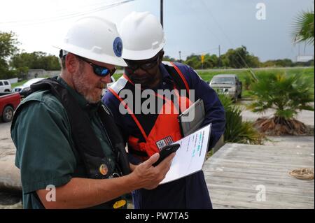 Coast Guard Petty Officer 2nd class Corey Drayton, eine Marine science Techniker Marine Safety Unit Texas City, Texas, und Texas General Land Office Senior Antwort Offizier Grau Powell zusammen arbeiten Zugewiesen den Status eines vertriebenen Schiff während der Auslagerung mit einem Plakat hier in Houston, Texas, zu dokumentieren, an Sept. 28, 2017. Die Küstenwache, die Texas General Land Office, die Texas Kommission auf die Umweltqualität und die Environmental Protection Agency wurden komplett in ein einheitliches Kommando mit der Mission Zuordnung entfernen von Vertriebenen oder teilweise eingetaucht Schiffe integriert Stockfoto