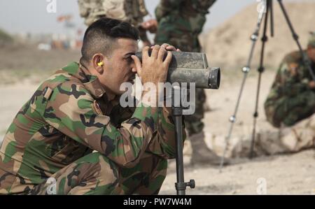 Ein Mitglied der irakischen Sicherheitskräfte schaut auf ein Ziel und einen anderen Trainer in der Treffsicherheit Ausbildung auf dem Camp Taji, Irak, Sept. 25, 2017 Regie. Camp Taji ist einer von vier Combined Joint Task Force - inhärenten Building Partner Kapazität beheben Standorte Ausbildung Partner Kräfte und Verstärkung ihrer Wirksamkeit auf dem Schlachtfeld gewidmet. CJTF-OIR ist die globale Koalition zu besiegen ISIS im Irak und in Syrien. Stockfoto