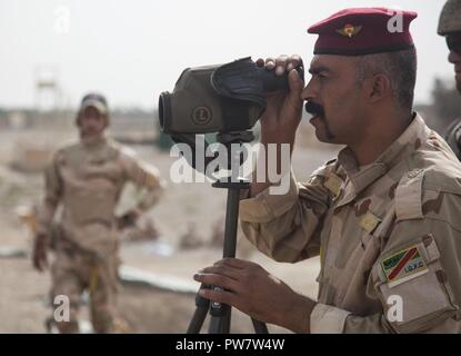 Ein Mitglied der irakischen Sicherheitskräfte schaut auf ein Ziel und einen anderen Trainer in der Treffsicherheit Training im Camp Taji, Irak, Sept. 25, 2017 Regie. Camp Taji ist einer von vier Combined Joint Task Force - inhärenten Building Partner Kapazität beheben Standorte Ausbildung Partner Kräfte und Verstärkung ihrer Wirksamkeit auf dem Schlachtfeld gewidmet. CJTF-OIR ist die globale Koalition zu besiegen ISIS im Irak und in Syrien. Stockfoto