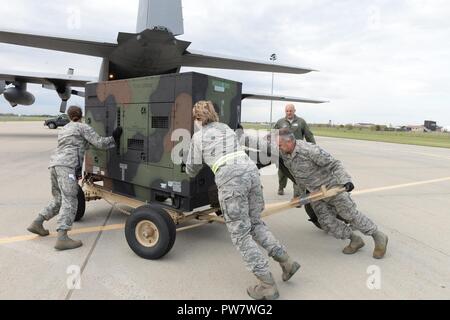 Us-Flieger auf der 119 Logistik Bereitschaft Geschwader zugewiesen. North Dakota Air National Guard, schieben Sie einen Generator auf einem Arkansas Air National Guard C-130 Flugzeugen, wie sie IT-Belastung für Luftbrücke in den U.S. Virgin Islands von der North Dakota Air National Guard Base, Fargo, N.D., Sept. 30, 2017. Der Generator ein Gerät gesendet wird als Teil einer Katastrophenhilfe Beddown (Drbs) an die Sturmkatastrophe in die Karibik geflogen, in die Folgen des Hurrikans Irma und Hurrikan Maria. Die drbs ist ein tragbares "Zeltstadt" für 150 Personen Haus, dass umfasst; Duschen, Stockfoto