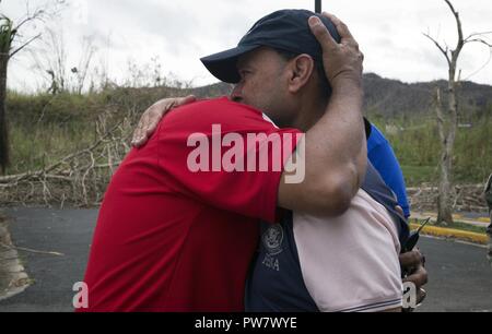 Comerío, PR, 30. September 2017 - Bürgermeister von Comerío Josian Santiago umarmt Kongressabgeordnete Luis Gutiérrez. Kongressabgeordnete Gutiérrez beteiligte sich an der Lieferung von FEMA Mahlzeiten zur Gemeinde Comerío. Yuisa Rios/FEMA Stockfoto