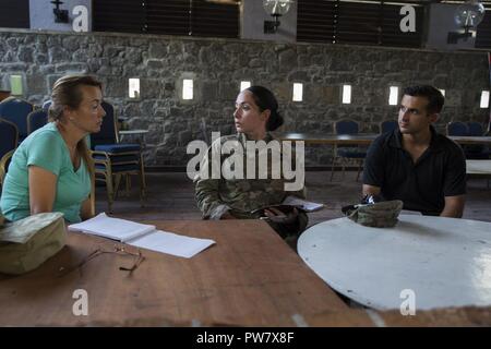 Us-Armee Maj. Rosmarin M. Reed, Mitte, eine zivil-militärische Angelegenheiten Offizier mit Joint Task Force - Leeward Inseln, und US-Marine Sgt. Jeffrey Borrego, rechts, eine zivile Angelegenheiten Spezialist mit JTF-LI, Treffen mit Veronika Martin, ein zivil-militärischer Koordinator mit der US-Agentur für Internationale Entwicklung von ausländischen Development Agency, in Roseau, Dominica, zukünftige Maßnahmen zur Unterstützung der Hurricane Relief auf der Insel zu diskutieren, Oktober 1, 2017. Auf Wunsch von USAID, JTF-LI hat eingesetzten Flugzeuge und Service Mitglieder in der Bereitstellung von Hilfsgütern zu Dominica in der afterm zu unterstützen. Stockfoto