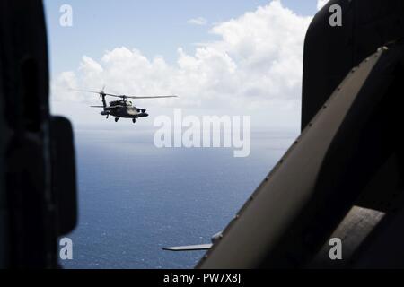 Ein U.S. Army UH-60 Black Hawk Helikopter mit Joint Task Force - Leeward Inseln über dem karibischen Meer fliegt, wie es in Richtung Hafen von Roseau, Dominica Köpfe, Wasser, Menschen durch den Hurrikan Maria, 01.10.2017, betroffen zu liefern. Auf Antrag der US-Agentur für Internationale Entwicklung, JTF-LI bereitgestellt hat, Flugzeuge und Service Mitglieder in der Bereitstellung von Hilfsgütern zu Dominica in der Nachmahd des Hurrikans Maria zu unterstützen. Die Task Force ist in den USA eine militärische Einheit, die aus Marinen, Soldaten, Matrosen und Fliegern und stellt erste Reaktion US Southern Command zu den Hurrikanen, Stockfoto