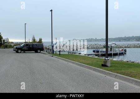 Vertreter der Michigan State Police Marine Services Team starten ihre relativ neuen sicheren Boot (Mai 2017, Sichere Rund-um-Börsengang vorhanden), das für die Teilnahme an der Operation Shining Star, Sept. 23, 2017 in der Bereitstellungsposition und Bootsanlegestelle in St. Ignace, Michigan. Die Michigan National Guard, 1437Th Multi-Role Bridge Company, Ribbon Bridge Stücke sind auch Vorbereitung an den Start gehen und tragen Die Ming 51. Zivile Support Team in den Straßen von Mackinac während der State Emergency Management/MING 51 Übung. Stockfoto