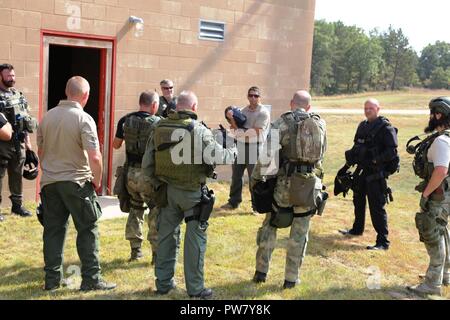 Wisconsin Strafverfolgungsbehörden Personal von einigen Grafschaften sammeln die Ergebnisse eines Schulungsszenarios Sept. 20, 2017 zu diskutieren, bei der kombinierten Waffen gemeinsamen Training Facility (CACTF) am Fort McCoy, Wis das Personal von Polizei in Wisconsin kam, und sie waren Teil der Ausbildung gelehrt von George Rahmtopf der integrierten taktischen Konzepten (ITC) LLC von Los Angeles. Mehr als 50 Mitarbeiter wurden in zwei Kursen über mehrere Tage Training im September, einschließlich Taktische gepanzerten von ITC Fahrzeug im eigenen Betrieb und Kursen unterrichtet. Die CACTF Komplex wird regelmäßig für Recht verwendet - enfor Stockfoto