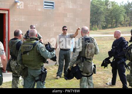 Wisconsin Strafverfolgungsbehörden Personal von einigen Grafschaften sammeln die Ergebnisse eines Schulungsszenarios Sept. 20, 2017 zu diskutieren, bei der kombinierten Waffen gemeinsamen Training Facility (CACTF) am Fort McCoy, Wis das Personal von Polizei in Wisconsin kam, und sie waren Teil der Ausbildung gelehrt von George Rahmtopf der integrierten taktischen Konzepten (ITC) LLC von Los Angeles. Mehr als 50 Mitarbeiter wurden in zwei Kursen über mehrere Tage Training im September, einschließlich Taktische gepanzerten von ITC Fahrzeug im eigenen Betrieb und Kursen unterrichtet. Die CACTF Komplex wird regelmäßig für Recht verwendet - enfor Stockfoto