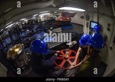 Hafen von HONG KONG (Okt. 2010) 2, 2017) - Deck Abteilung Matrosen die Bremse lösen der Port im Vorschiff der Marine vor Anker - bereitgestellt Flugzeugträger USS Ronald Reagan (CVN 76), als das Schiff Anker vor der Küste von China vor einer geplanten Hafen Besuch in Hongkong. Der Hafen besuchen kommt nach Routine Operationen in das Südchinesische Meer. Ronald Reagan, das Flaggschiff der Carrier Strike Group 5, bietet eine Bekämpfung bereit, Kraft, schützt und verteidigt die kollektive maritime Interessen seiner Verbündeten und Partnern in der Indo-Asia-Pazifik-Region. Stockfoto
