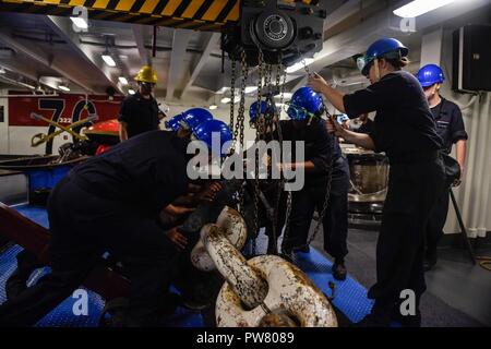 Hafen von HONG KONG (Okt. 2010) 2, 2017) - Deck Abteilung Seeleute sichere den Port im Vorschiff der Marine vor Anker - bereitgestellt Flugzeugträger USS Ronald Reagan (CVN 76), als das Schiff Anker vor der Küste von China vor einer geplanten Hafen Besuch in Hongkong. Der Hafen besuchen kommt nach Routine Operationen in das Südchinesische Meer. Ronald Reagan, das Flaggschiff der Carrier Strike Group 5, bietet eine Bekämpfung bereit, Kraft, schützt und verteidigt die kollektive maritime Interessen seiner Verbündeten und Partnern in der Indo-Asia-Pazifik-Region. Stockfoto