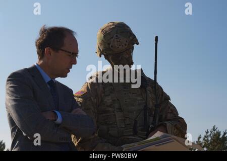 US Army Oberst James Bartholomees, Brigadegeneral der 173Rd Airborne Brigade, Schriftsatz Paul Poletes, Stellvertretender Leiter der Mission der US-Botschaft in Lettland, auf die Ereignisse des Tages bei einem kombinierten Waffen live fire Übung in Adazi, Lettland am 2. Oktober 2017. Die Kämpfe poletes Fähigkeiten der NATO-Streitkräfte an Bajonett Schild, einer Region, die weit in der Baltischen Staaten zu demonstrieren, die betriebliche Flexibilität in realistischen Übungen zwischen den USA und ihren NATO-Verbündeten und Partner erlebt. Stockfoto