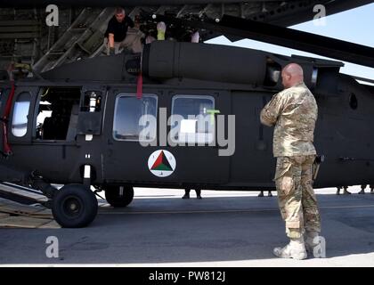 Us Air Force Colonel Armando Fiterre, die 738Th Air Expeditionary Advisory Group Commander, Trainieren, beraten, unterstützen, Command-Air, Uhren wie die ersten Afghanischen Luftwaffe UH-60 Hubschrauber aus entladen ist ein US Air Force C-17 Globemaster, Sept. 18, 2017, in Kandahar Air Field, Afghanistan. Die UH-60 Ankunft ist Teil der Rekapitalisierung Bemühungen der AAF. Der Plan umfasst sieben verschiedene Waffensysteme, 14 Programm Büros und mehr als 20 wichtige Verträge. TAAC - Luft wird die Ausbildung von AAF-Piloten und Betreuer. Stockfoto