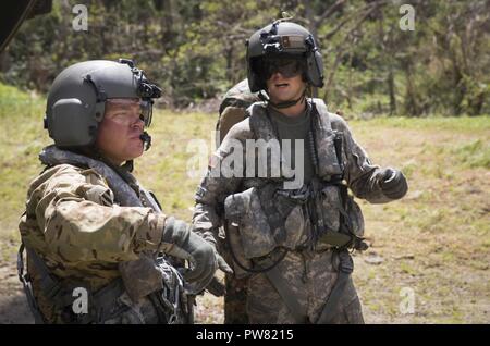 Us-Armee Sgt. Arthur W. Hinkle, Links, und Sgt. Delton Reynolds, die beiden Flugingenieure mit Joint Task Force - Leeward Inseln, koordinieren die Entladung der Hilfsgüter von einem CH-47 Chinook Hubschrauber Wotten Waven, Dominica, Oktober 3, 2017. Auslieferung des Flugzeuges Sack Reis und Küche Sets aus der US-Agentur für Internationale Entwicklung der Gemeinschaft. Auf Wunsch von USAID, JTF-LI hat eingesetzten Flugzeuge und Service Mitglieder in der Bereitstellung von Hilfsgütern zu Dominica in der Nachmahd des Hurrikans Maria zu unterstützen. Die Task Force ist in den USA eine militärische Einheit aus Marines, Soldaten, Stockfoto