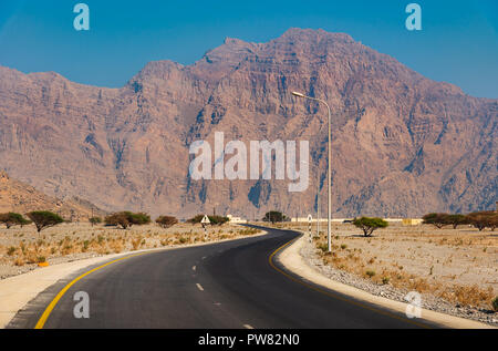 Malerische Wüste Straße von Felsen in Musandam Oman umgeben Stockfoto