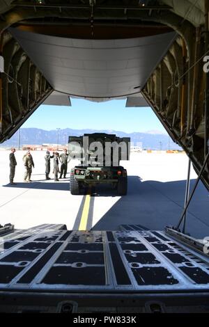 Soldaten aus 3 Colorado Armee der Nationalen Wachbataillon, 157 Field Artillery, bereiten ihre High Mobility Artillery Rocket System auf eine Hercules C-130 Flugzeugen aus den 41 Airlift Squadron zu laden, 19 Airlift Wing, Little Rock Air Force Base in Colorado Springs, Colo., Flughafen für Lieferung in Fort Carson, Sept. 20, 2017. Zur Unterstützung der Übung War Horse Streik, diese gemeinsame Mission zwischen 3-157 th FA und der 19 Airlift Wing, 41 Airlift Squadron, von Little Rock Air Force Base, half nicht nur, die Anforderung des Bataillons ihre HIMARS zur Luftbrücke und Verhalten" heißen Panel "tra Treffen Stockfoto