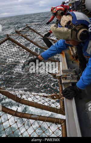 Irische See (Okt. 2010) 3, 2017) Segler senken Sie den Flight Deck Verrechnung an Bord der Arleigh-Burke-Klasse geführte Anti-raketen-Zerstörer USS Donald Cook (DDG75) Flugbetrieb während der Übung gemeinsame Krieger 17-2, Okt. 3, 2017 durchzuführen. Gemeinsame Krieger ist ein UK-led, multinationale Übung, die Interoperabilität und die Zusammenarbeit in allen Bereichen anwendbar Kriegsführung entwickelt. Stockfoto