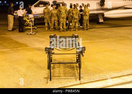 Us-Armee Finden und aktiven Soldaten mit Bundes Koordinierungsstelle Columbia unterstützen eine Patientin, die von der Jungfrau Inseln evakuiert wurde nach dem Hurrikan Maria Okt. 2 im Columbia Metropolitan Airport in Columbia, S.C. Die FCC Columbia Team war für die Aufnahme von Patienten in die Folgen des Hurrikans Maria evakuiert auf Flügen von Puerto Rico und den U.S. Virgin Islands verantwortlich, die Bewertung der Patienten, und dann Sie mit Sorgfalt an einem lokalen Krankenhaus. FCC-Columbia, ein Team unter der Leitung von US-Armee Reservisten, war der erste Verteidigungsministerium Team aktiviert werden. Stockfoto