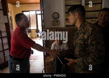 Us Marine Corps Sgt. Pedro L. Emmanuelli, eine Landung Support Specialist mit loslösung 1, Landung Support Unternehmen, Bekämpfung Logistik Regiment 45, 4 Marine Logistik Gruppe, seine Dienstleistungen Freiwilligenarbeit mit dem 26 Marine Expeditionary Unit (MEU), interagiert mit einer Freiwilligen nach helfende auf Nahrung für die Gemeinschaft an einem lokalen Heilsarmee in Fajardo, Puerto Rico, Oktober 3, 2017. Die 26. MEU, zusammen mit den lokalen Behörden und anderen Verteidigungsministerium Dienstleistungen, unterstützt die Leitung Bundesamt, Federal Emergency Management Agency, die in der Humanitären Hilfe Bemühungen für Puerto Rico. Stockfoto
