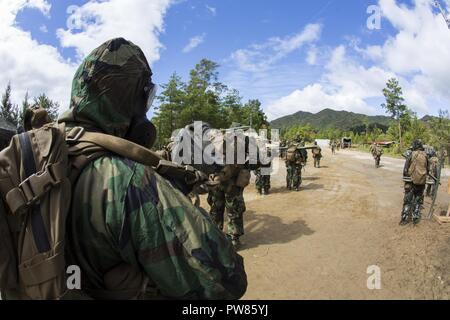 Us-Marines Marine Wing Support Squadron (MWSS) 171 für eine Patrouille in Mission Oriented schützende Haltung (MOPP) Gang während der Übung Kamoshika Zorn vorbereiten auf Haramura Manöver, Japan, Oktober 3, 2017. Die Übung ermöglicht Marines mission Leistung zu testen und beruflichen Anforderungen, indem Sie sie in realen Szenarien erfüllen. MOPP gear geschützt Marines von potentiell gefährlichen Gase, wie sie bei der defensive Maßnahmen durchgeführt und Löcher gegraben Kämpfen während eines simulierten Angriff. Stockfoto