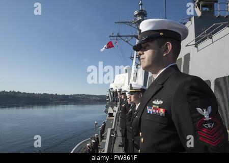 EVERETT, Washington (Okt. 3, 2017) Segler die Schienen der Arleigh-Burke-Klasse geführte Anti-raketen-Zerstörer USS Sampson (DDG102) als das Schiff fährt Naval Station Everett, Washington Sampson ist Teil der Theodore Roosevelt Carrier Strike Group, die Bereitstellung wird mit der Geführten-missile Cruiser USS Bunker Hill (CG52) und geführt - Flugzerstörer USS Halsey (DDG97) und USS Preble (DDG88) und dem Flugzeugträger USS Theodore Roosevelt (CVN 71). Stockfoto