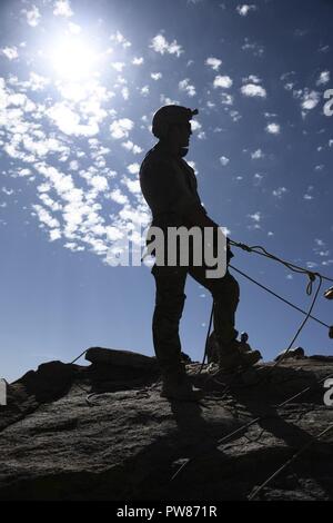 Ein US Air Force pararescueman vom 68th Rescue Squadron zwischen dem sichern und die pararescueman belay Crew während einer Übung im Coronado National Forest in Tucson, Ariz., Sept. 26, 2017 kommuniziert. Die 68Th RQS bietet pararescuemen und zur Bekämpfung der Rettung Offiziere 5 und 7-Upgrade Training in der Land Warfare und Personal Recovery. Stockfoto