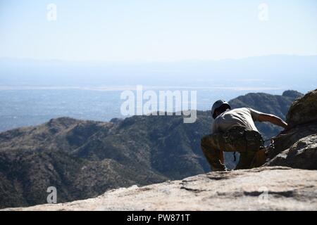 Ein US Air Force pararescueman vom 68th Rescue Squadron zwischen dem sichern und die pararescueman belay Crew während einer Übung im Coronado National Forest in Tucson, Ariz., Sept. 26, 2017 kommuniziert. Der Kurs vermittelt den effizientesten und sichersten Möglichkeiten, erfolgreich zu Berg führen Sie rettet, zu hohen und niedrigen Winkel rettet, Klettern und Sichern. Stockfoto