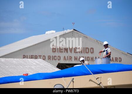 Mitglieder der 156 Tiefbau squadron Reparatur des Dachs durch Hurrikan Maria an der Muniz Air National Base, Puerto Rico beschädigt mit einer der weithin anerkannten FEMA blaue Blätter. Stockfoto