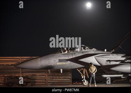 Piloten den Expeditionary 492nd Fighter Squadron zugeordnet und Betreuer aus dem 332 Expeditionary Maintenance Squadron finish vor Auf einer F-15E Strike Eagle vor einem frühen Abflug am 4. Oktober 2017, an einem geheimen Ort im Südwesten Asien. Die 492Nd EFS ist wieder in ihre Heimat nach sechs Monaten der unerbittlichen Streiks gegen die islamischen Kräfte in der Region. Stockfoto