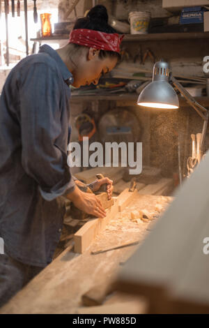 Die Frau ist bei der Verarbeitung von Holz in der Werkstatt tätig. Handgefertigte Konzept. Lifestyle der Handwerker Stockfoto