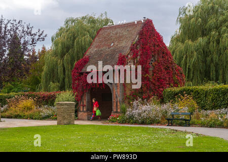 Herbst Tag Blick auf Frau Entlang Pfad durch lych gate Taubenschlag, in schönen, friedlichen, kommunale Rowntree Memorial Park, York, England, UK. Stockfoto