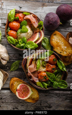 Herby Salat, frische Feigen, gebackene Tomaten, Basilikum und frisch gerösteten Knoblauch Toast Stockfoto