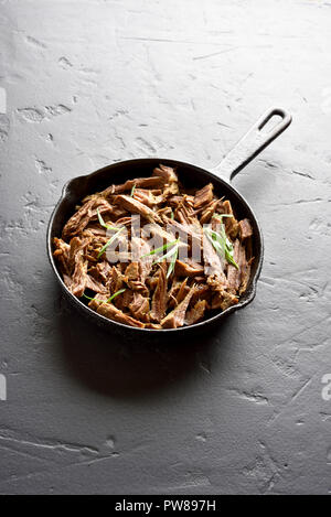 Langsam zog gekocht Rindfleisch für Sandwiches in Pfanne bei schwarzen Stein Hintergrund mit kopieren. Stockfoto