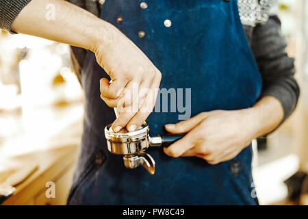 Nahaufnahme von Barista mit Stampfer und Kolben oder portafilter Espresso zu machen. Stockfoto