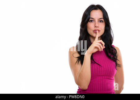 Studio shot der jungen schönen spanischen Frau mit den Finger auf die Lippen Stockfoto