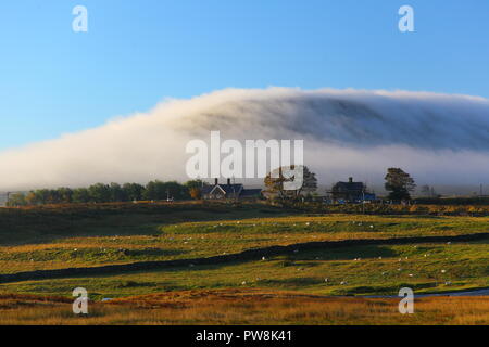 Ingleborough peak eingehüllt in eine Wolke von sanften Nebel, der die Konturen der großen Hügel in den Yorkshire Dales National Park folgt Stockfoto