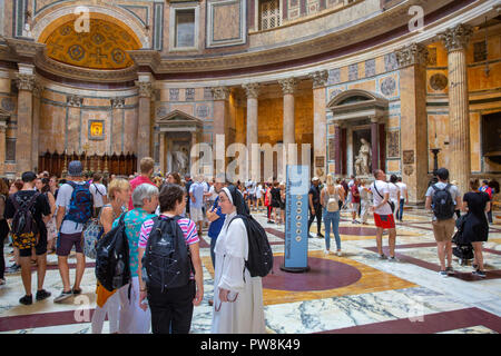 Eine Nonne in weißem Kleid schließt sich Touristen und Besucher insdide das Pantheon in Rom im Inneren der historischen Struktur anzuzeigen, Rom, Italien Stockfoto