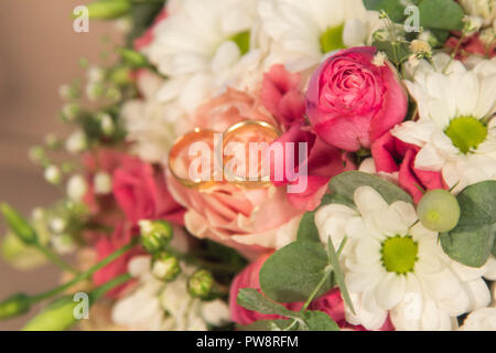 Close-up Hochzeit Ringe auf der natürlichen Rosen Blumenstrauß Stockfoto