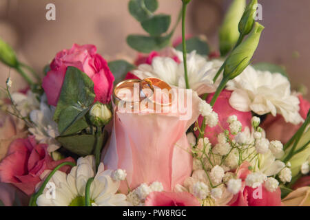 Trauringe auf schönen natürlichen Blumen Blumenstrauß Stockfoto