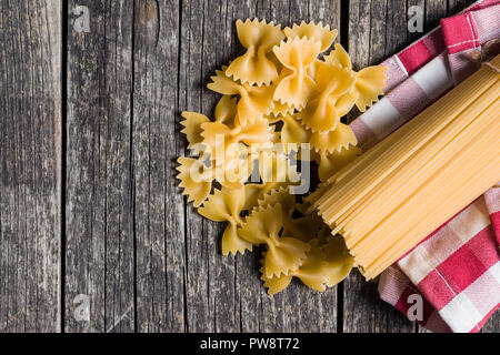 Spaghetti und farfalle Pasta auf alten Holztisch. Ansicht von oben. Stockfoto