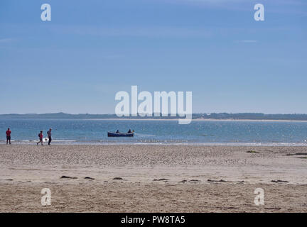 Einen kleinen Lokalen Fischerboot mit 2 Fischer legen ihre Netze in der Nähe der Strand bei Beadnell Bay in Northumberland, England, UK. Stockfoto