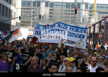 Frankfurt am Main, Deutschland. 13. Oktober 2018. Die Demonstranten halten ein Banner mit der Aufschrift "die Mutter aller Probleme: Die Meinungsverschiedenheiten zwischen uns und der fette Katzen'. Über 3.500 Menschen durch Frankfurt marschierte, um gegen Rassismus und für Toleranz zu protestieren. Sie wurden von vielen lokalen Bands, die auf dem Weg und auf den Kundgebungen begleitet. Der Protest war ein Teil von mehreren anderen Proteste gegen Rassismus in Deutschland am selben Tag. Quelle: Michael Debets/Alamy leben Nachrichten Stockfoto